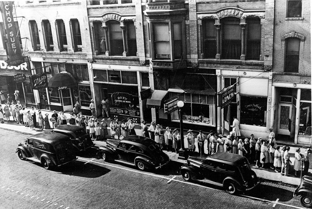 The Oriental Cafe's "Chop Suey" sign can be seen at far left above the 400 block of East Monroe Street in 1943. (The line of pedestrians is queued up to redeem meet ration coupons at the Monroe Street Market, which is beyond the west edge of the photo. (Sangamon Valley Collection)