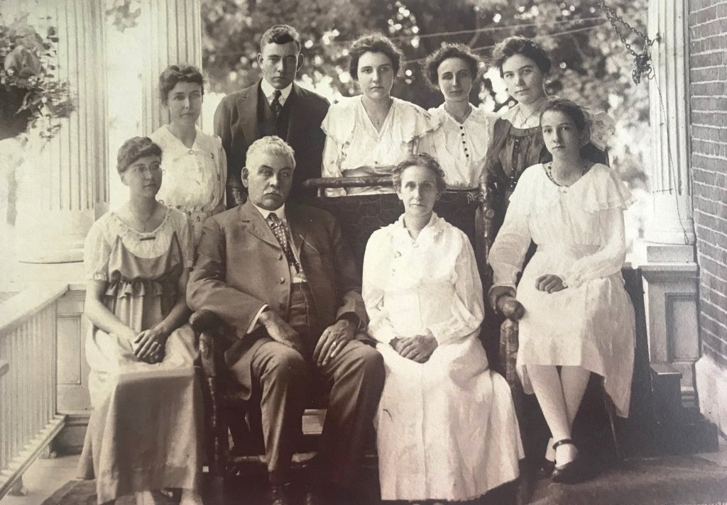 Charles and Amy Reed (seated center) with seven of their eight  children, photographed on the porch of the Sangamon County Poor Farm main building. Helen Reed Herrin, mother of contributor Elaine Burrus, is seated right. (Courtesy Elaine Burrus)