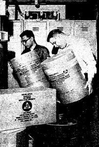 Dave Roscetti, left, and Bill Marsh stack sanitation kits (cardboard drums that served as toilets) during the 1964 State Office Building drill. (Courtesy SJ-R)
