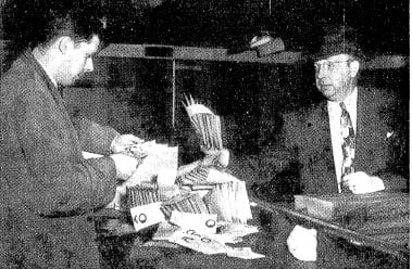Asst. state's attorney Robert Oxtoby, left, and sheriff's deputy Ray Crowder inspect gambling "pull cards" after a 1951 raid. (SJR files)