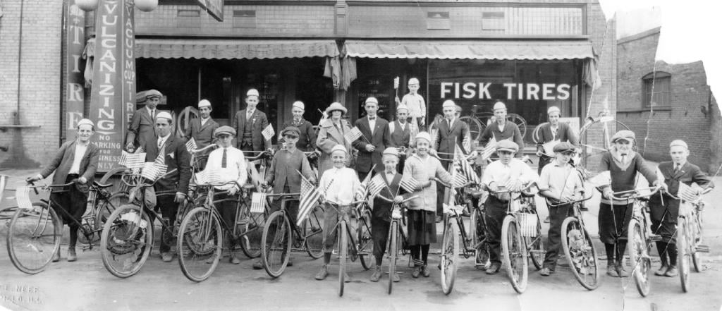 A group of newspaper carriers, with bikes all sporting Fisk tires, pose in front of the Fisk outlet in the 300 block of South Fourth Street, circa 1917. Several of the carriers sport lapel pins that suggest they may have been licensed as street vendors as well. (Sangamon Valley Collection)