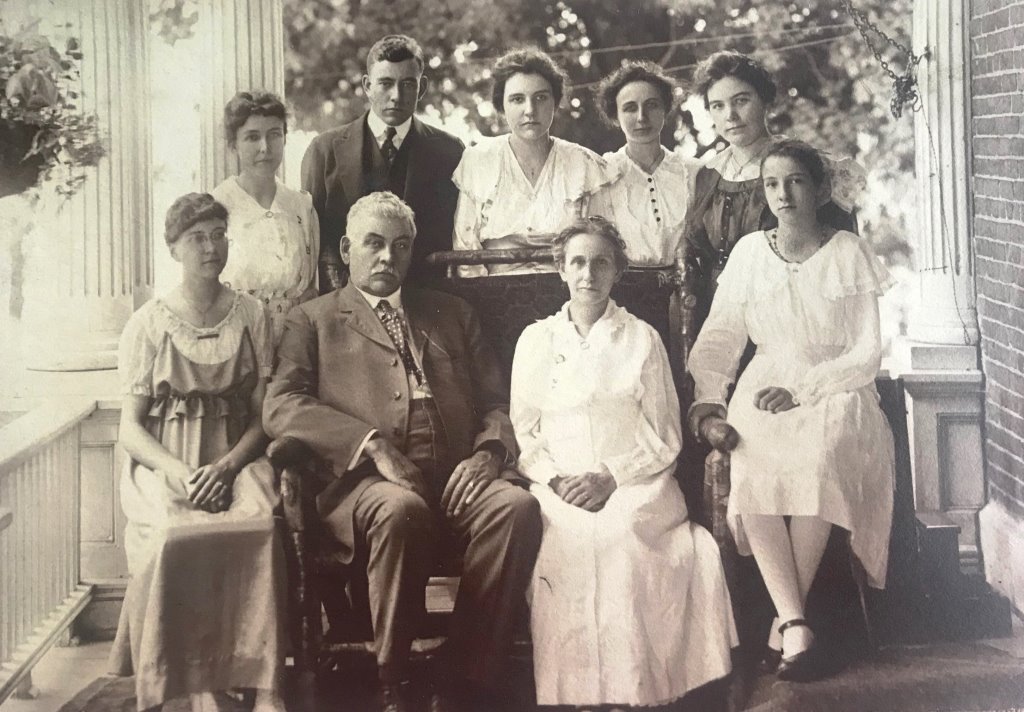 Charles and Amy Reed (seated center) with seven of their eight children, photographed on the porch of the Sangamon County Poor Farm main building. Helen Reed Herrin, mother of contributor Elaine Burrus, is seated right. (Courtesy Elaine Burrus)